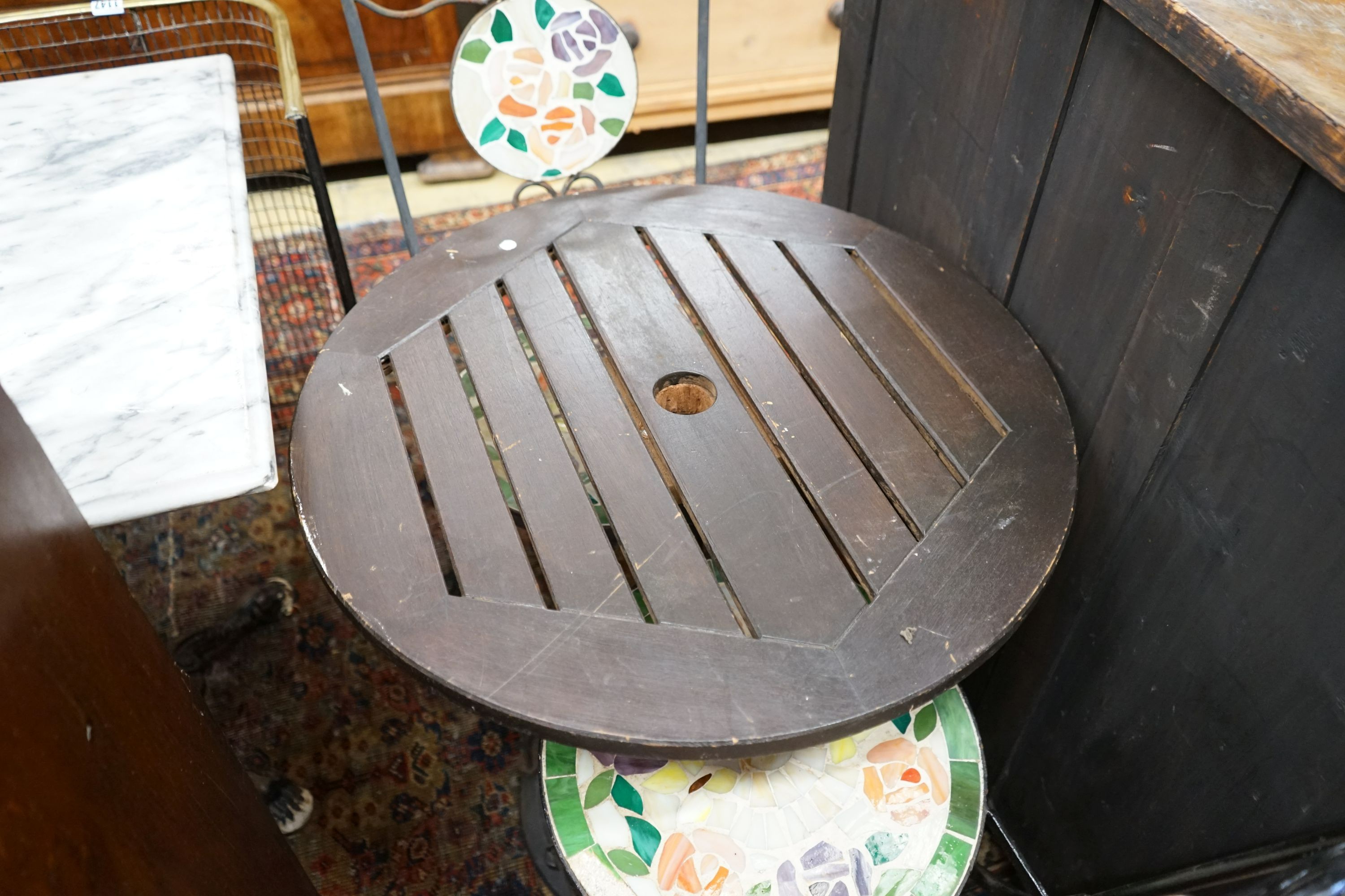 A circular cast iron based garden table, diameter 60cm together with two wrought iron mosaic folding chairs